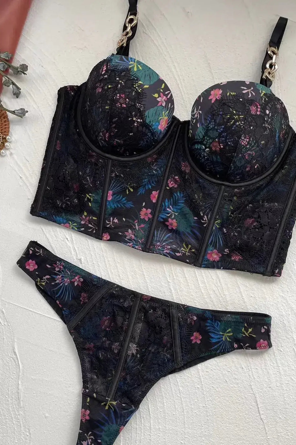 Black lingerie bodysuit for women laid flat to display back lace panel.