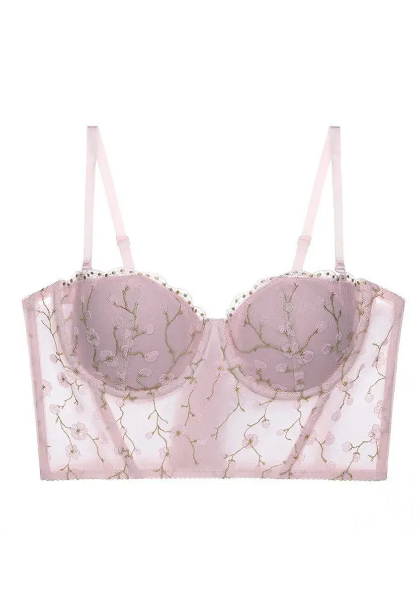 Display of blush pink bustier top lingerie with sheer embroidery and lace accents, soft and romantic style.