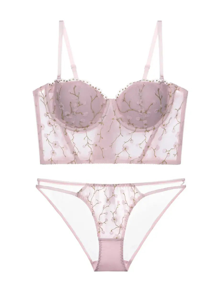 Flat lay back view of blush embroidered corset lingerie set with floral mesh and soft pink tones.