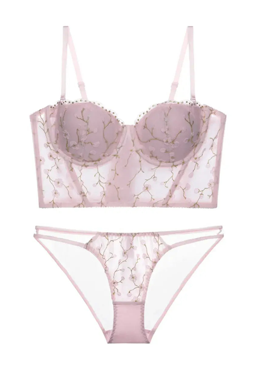 Flat lay back view of blush embroidered corset lingerie set with floral mesh and soft pink tones.