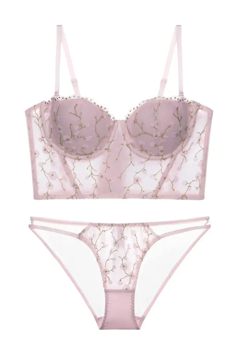 Flat lay back view of blush embroidered corset lingerie set with floral mesh and soft pink tones.