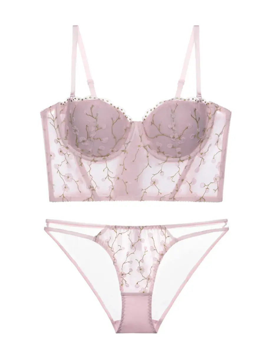 Flat lay back view of blush embroidered corset lingerie set with floral mesh and soft pink tones.