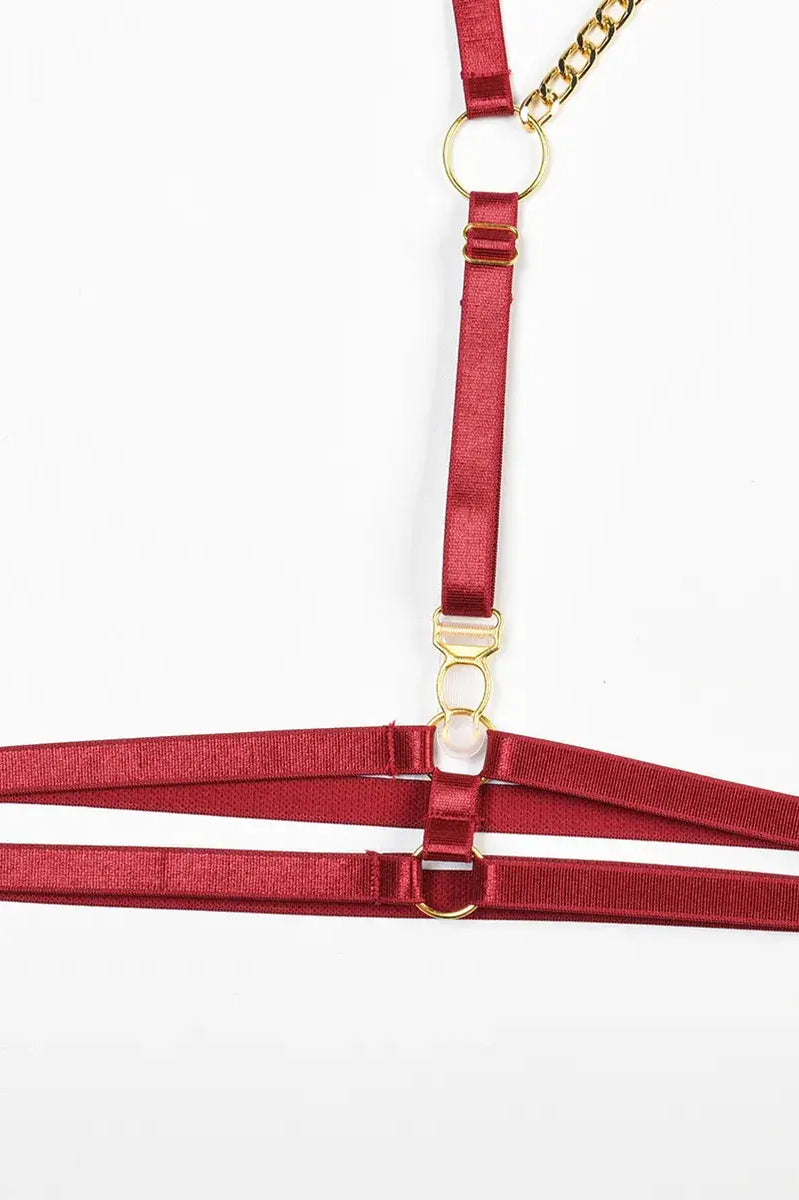 Glossy burgundy PU leather thigh harness with adjustable straps and gold sliders from the Crimson Obsession 5-piece lingerie set.