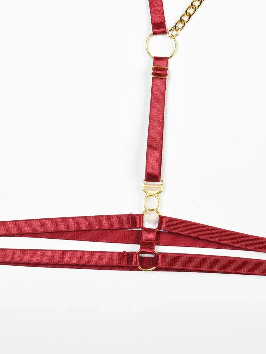 Glossy burgundy PU leather thigh harness with adjustable straps and gold sliders from the Crimson Obsession 5-piece lingerie set.