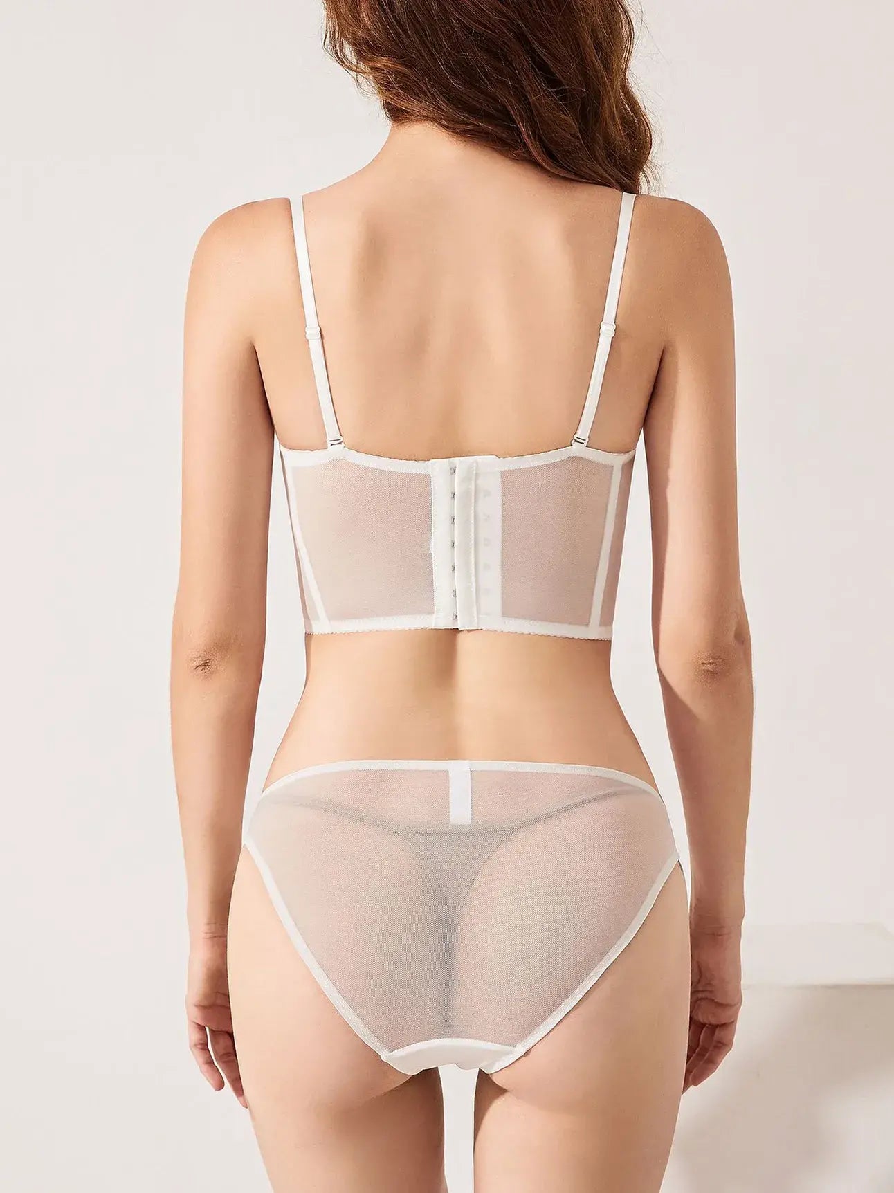 Back view of ivory lace corset top lingerie set featuring gold embroidery and sheer mesh, styled for both innerwear and outerwear.
