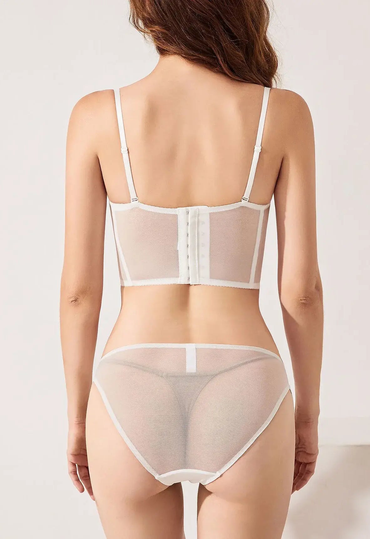 Back view of ivory lace corset top lingerie set featuring gold embroidery and sheer mesh, styled for both innerwear and outerwear.