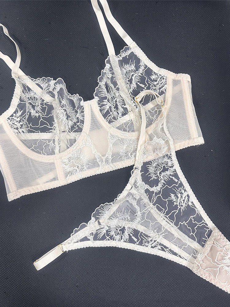 Flat lay of Ivory Whisper embroidered lingerie set showing lace fabric placement and visual balance of corset and thong.