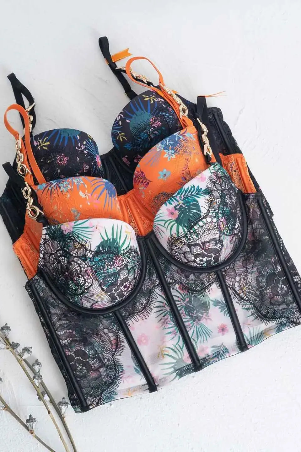 Lace lingerie set flatlay in orange, black, and white color variations.