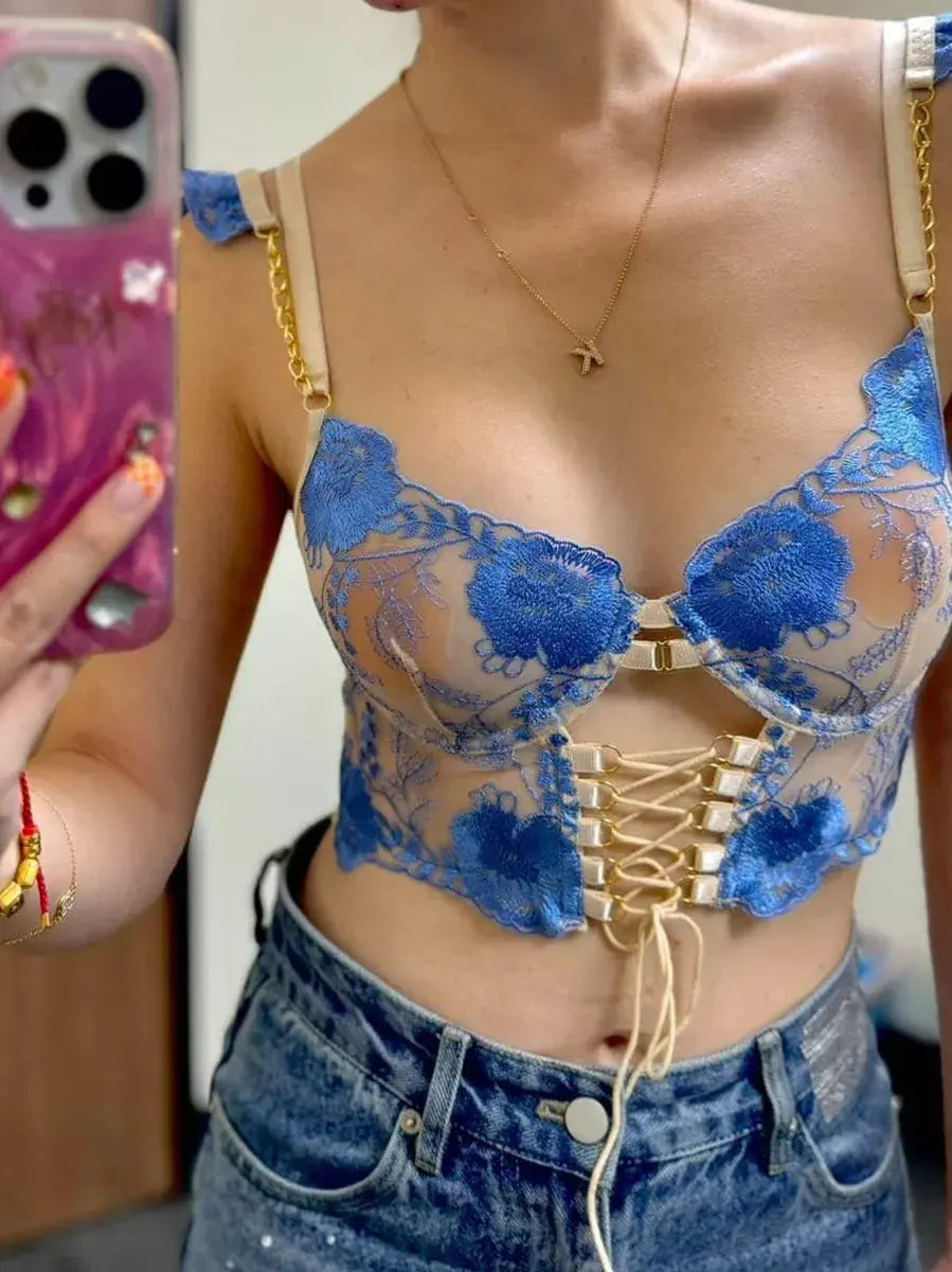 Close-up of woman's sheer mesh corset top showcasing intricate embroidery and translucent fabric