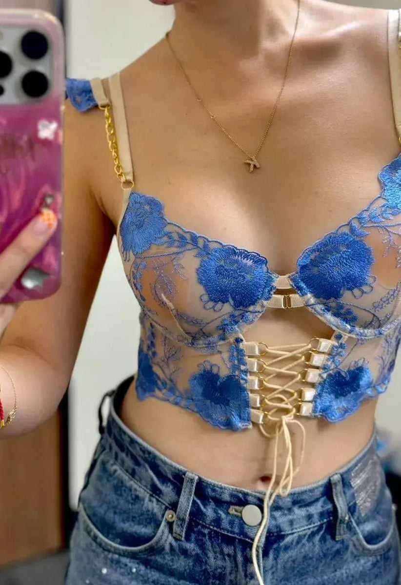 Close-up of woman's sheer mesh corset top showcasing intricate embroidery and translucent fabric