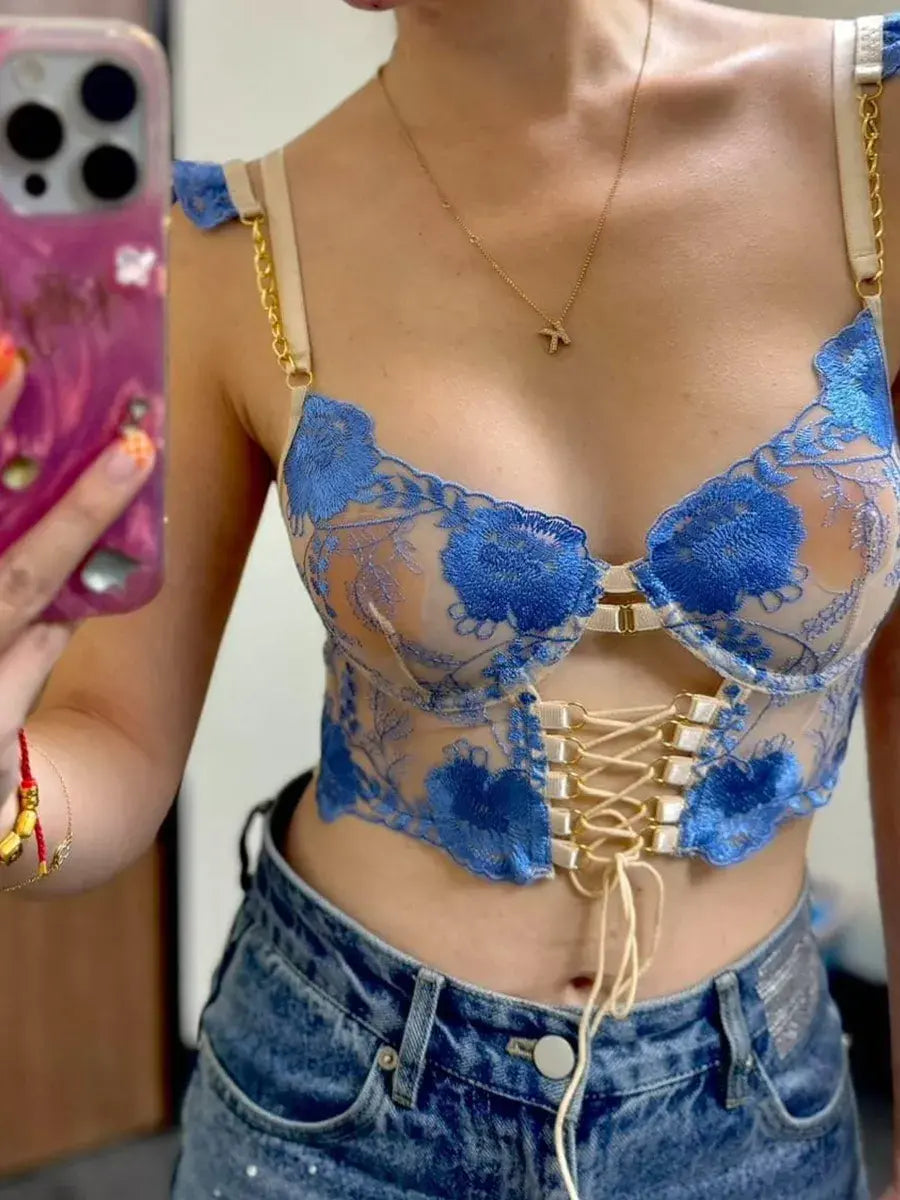 Close-up of woman's sheer mesh corset top showcasing intricate embroidery and translucent fabric