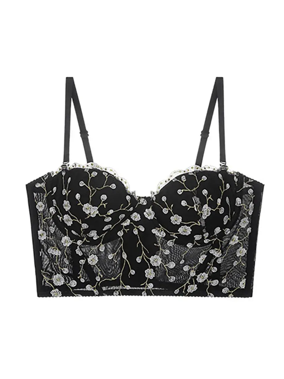 Display of black bustier top lingerie with golden embroidery and sheer lace accents, elegant and bold.