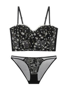 Flat lay back view of black and gold embroidered corset lingerie set, showcasing mesh structure and lace finish.