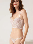 Front side angle of pink embroidered lingerie bodysuit, revealing confident feminine curves and delicate lace.