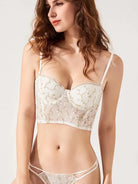 Close-up of sheer bustier top with intricate gold embroidery and lace textures, emphasizing delicate craftsmanship.