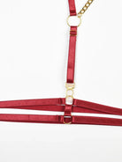 Glossy burgundy PU leather thigh harness with adjustable straps and gold sliders from the Crimson Obsession 5-piece lingerie set.