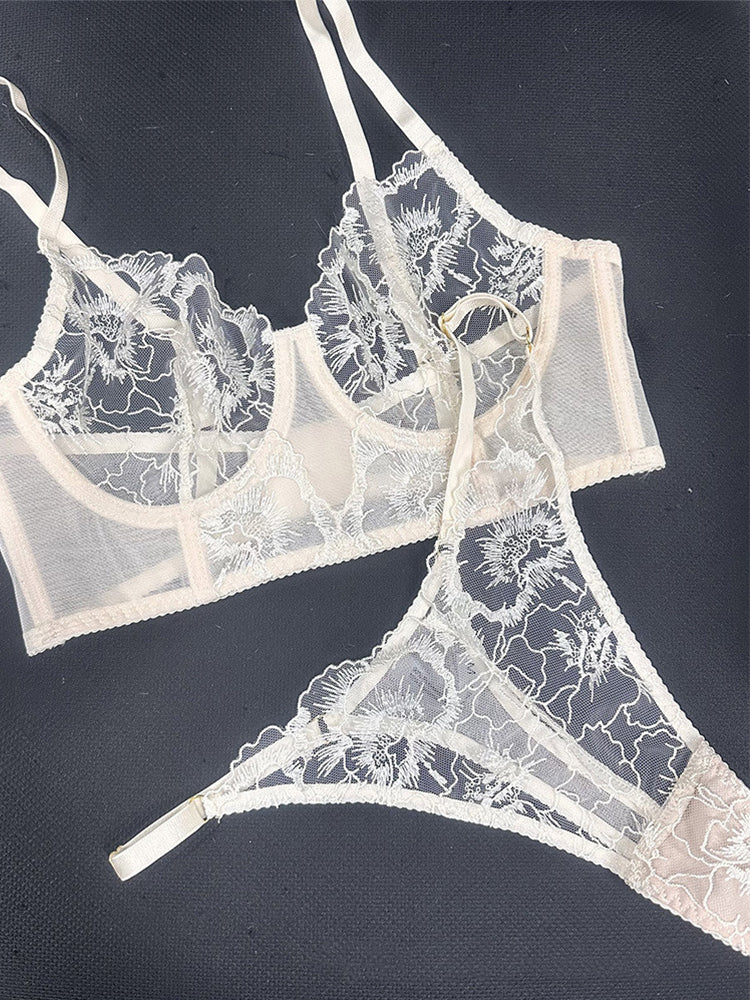 Flat lay of Ivory Whisper embroidered lingerie set showing lace fabric placement and visual balance of corset and thong.