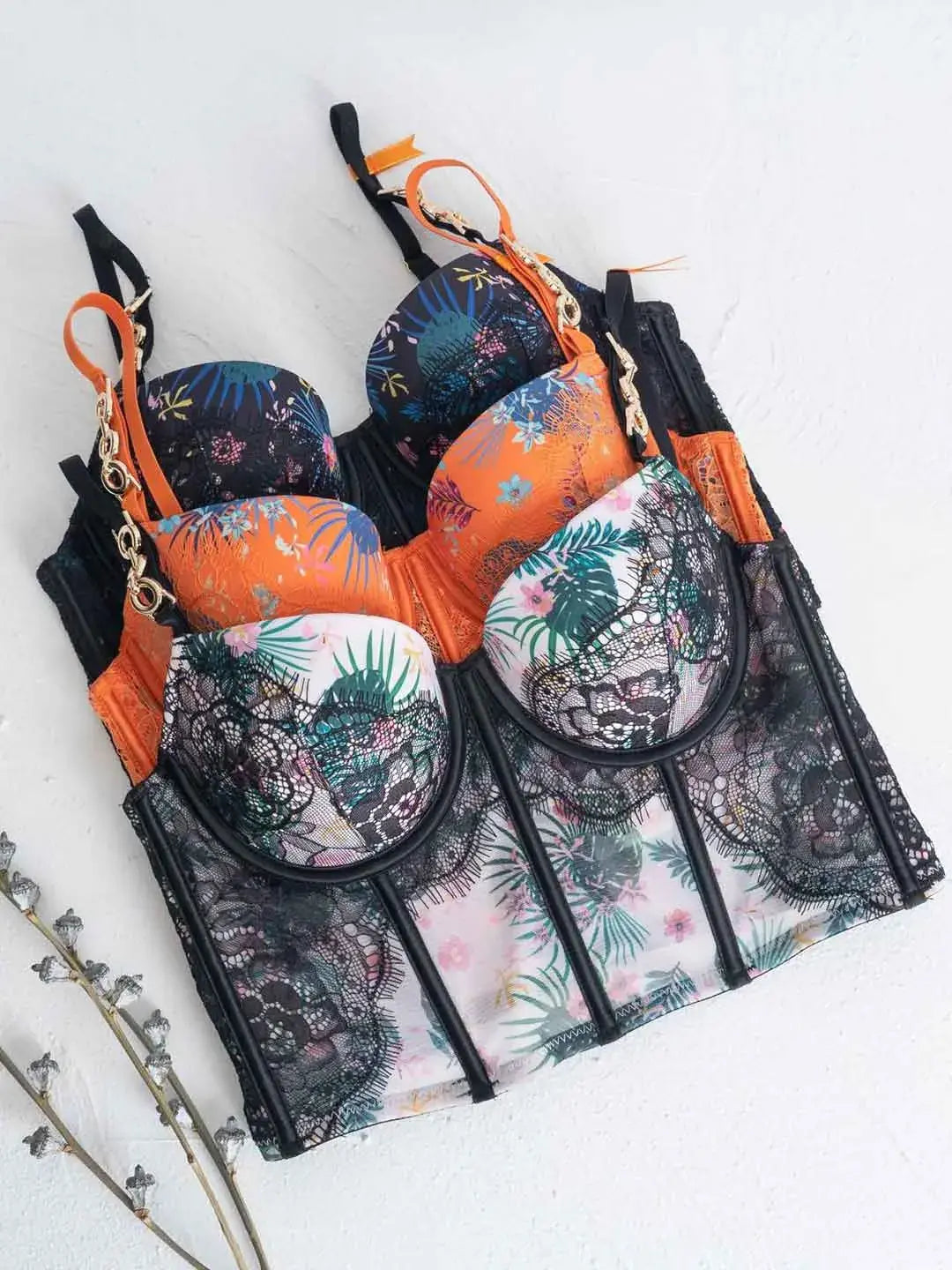 Lace lingerie set flatlay in orange, black, and white color variations.