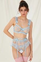 Model wearing the light blue lingerie set showing the floral embroidery and sheer details from the front.