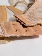 Nude bra underband hook closure design for a secure fit.