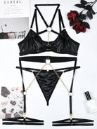 Flat lay display of black PU leather neckpiece and gold chain accessories included in the Obsidian Edge lingerie set.