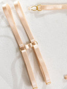 Refined nude leather leg bands with metallic accents and elastic fit from the Velvet Armor lingerie collection.